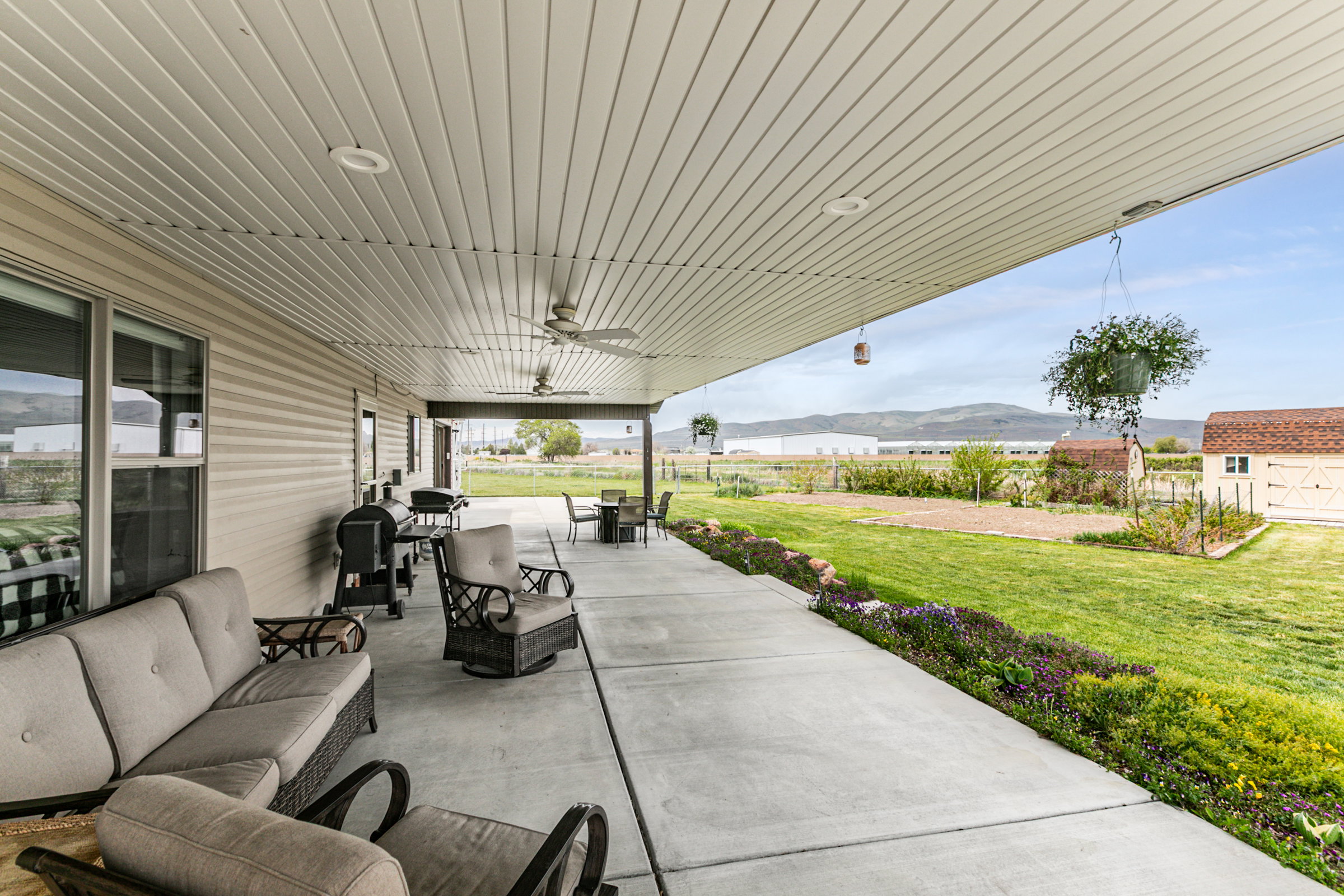 Expansive covered patio with concrete flooring and a paneled ceiling