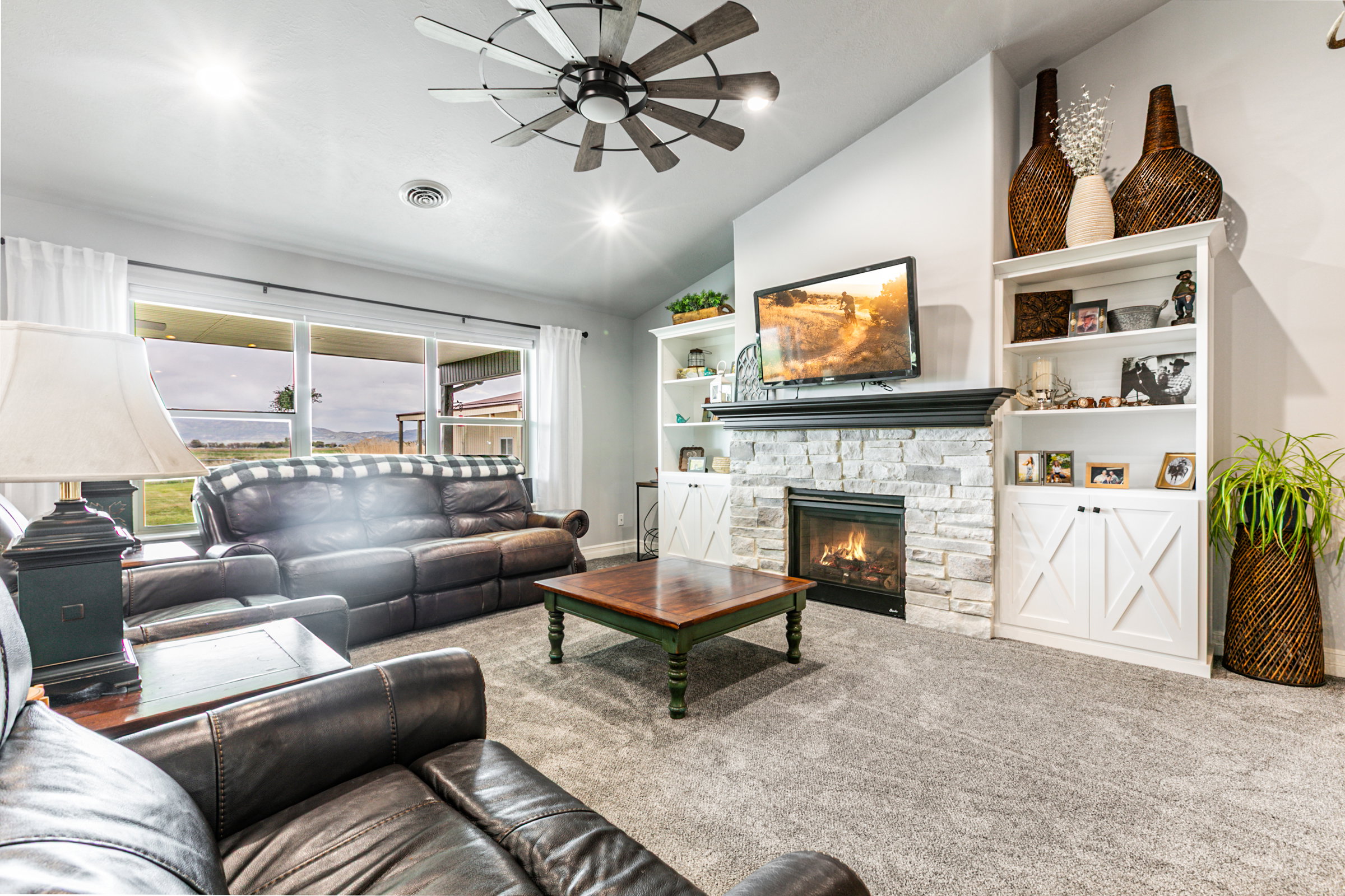 Living area with a stone-clad fireplace and built-in shelving