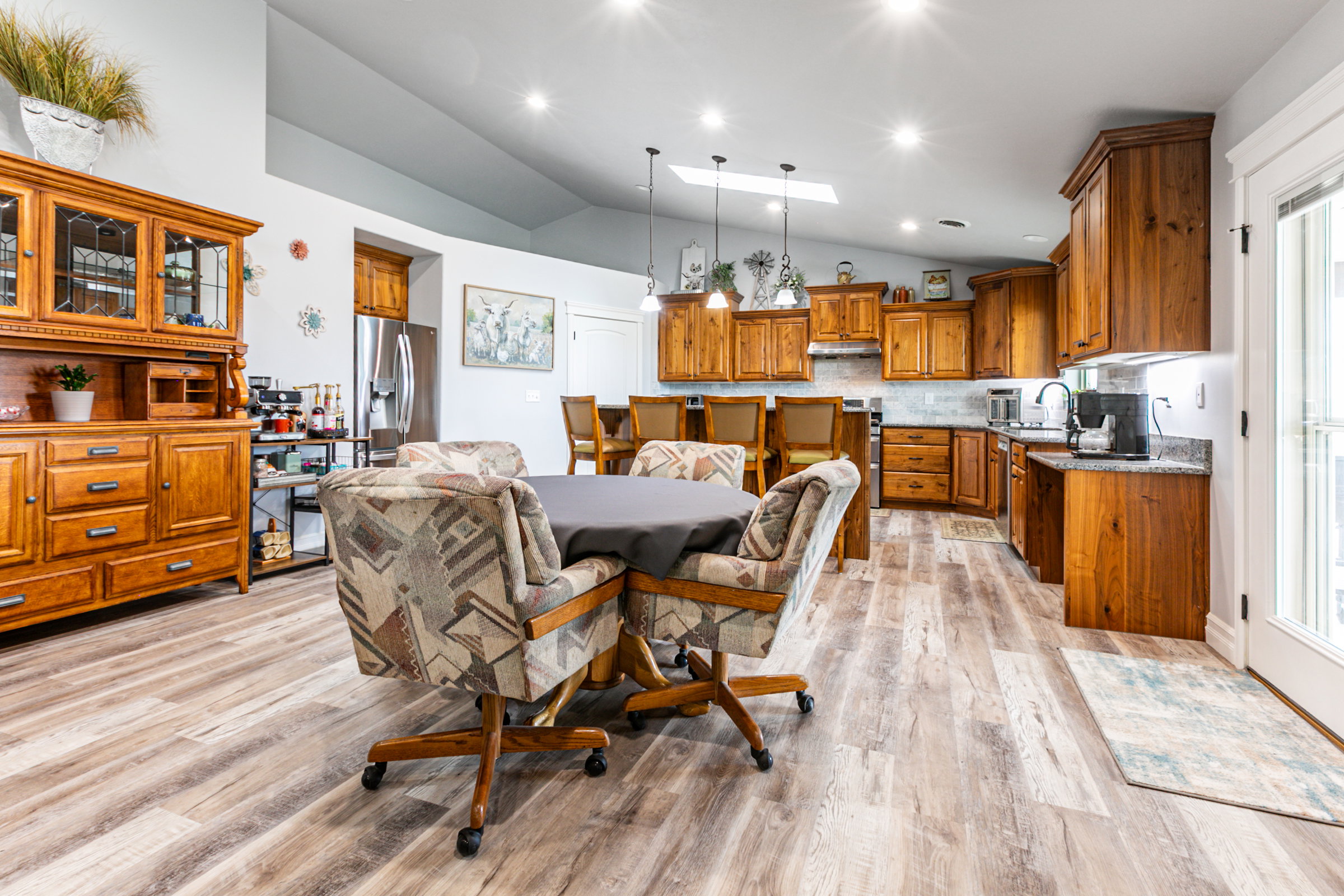 Spacious kitchen featuring wood cabinetry, stone-finish countertops, and stainless steel appliances
