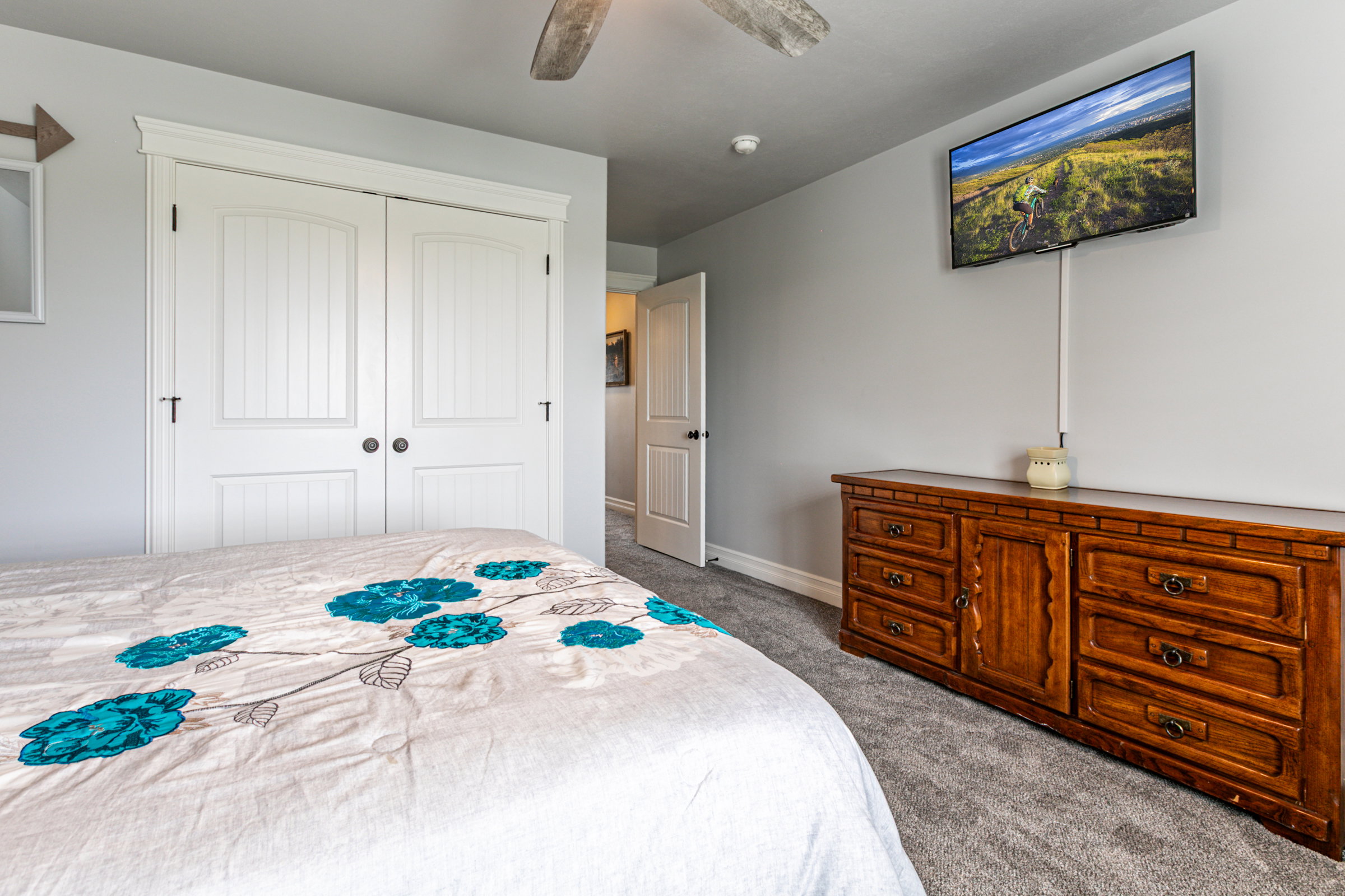 Built-in closet with white paneled bifold doors and dark hardware