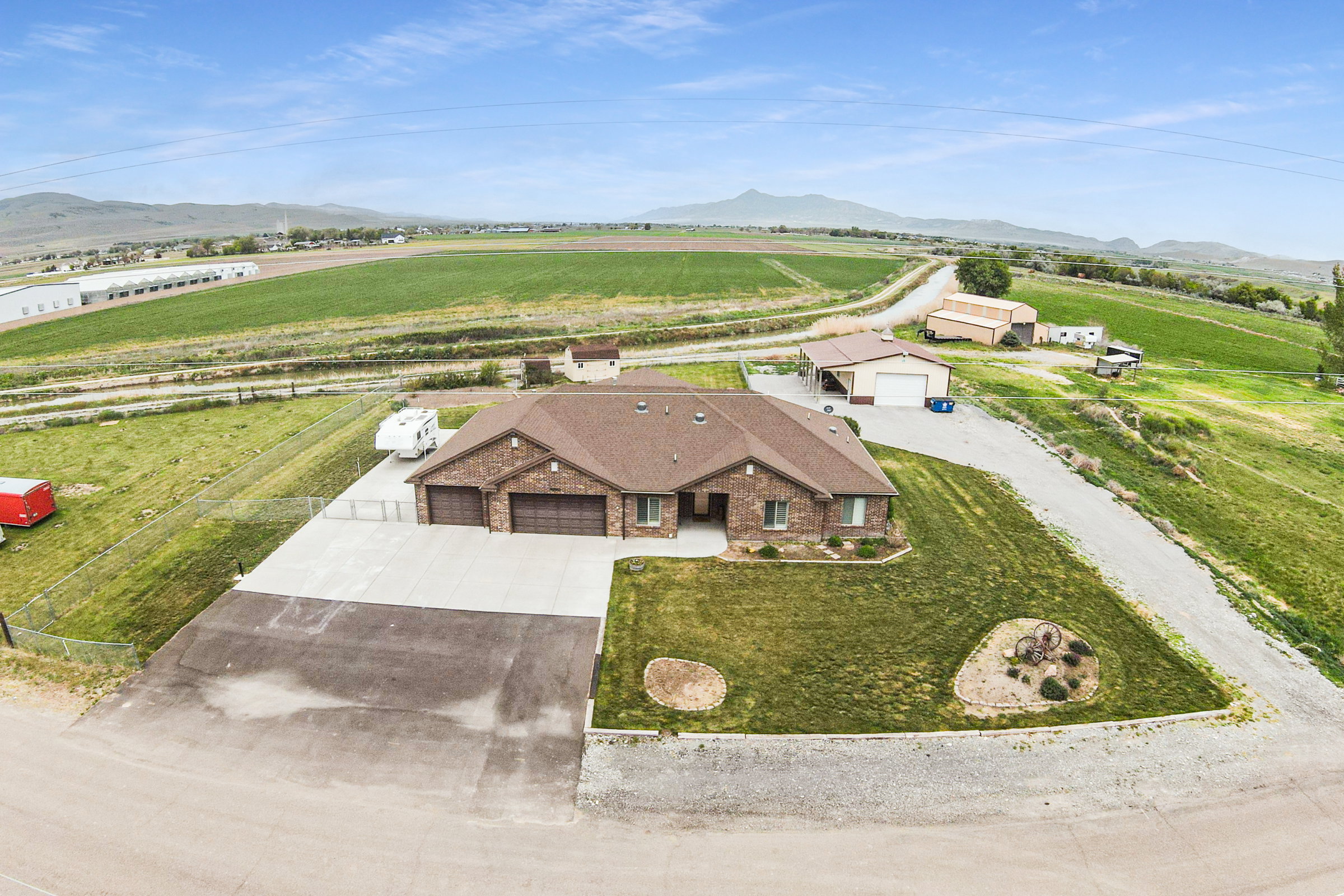 Brick single-story residence featuring a three-car garage, concrete driveway, and a landscaped front yard