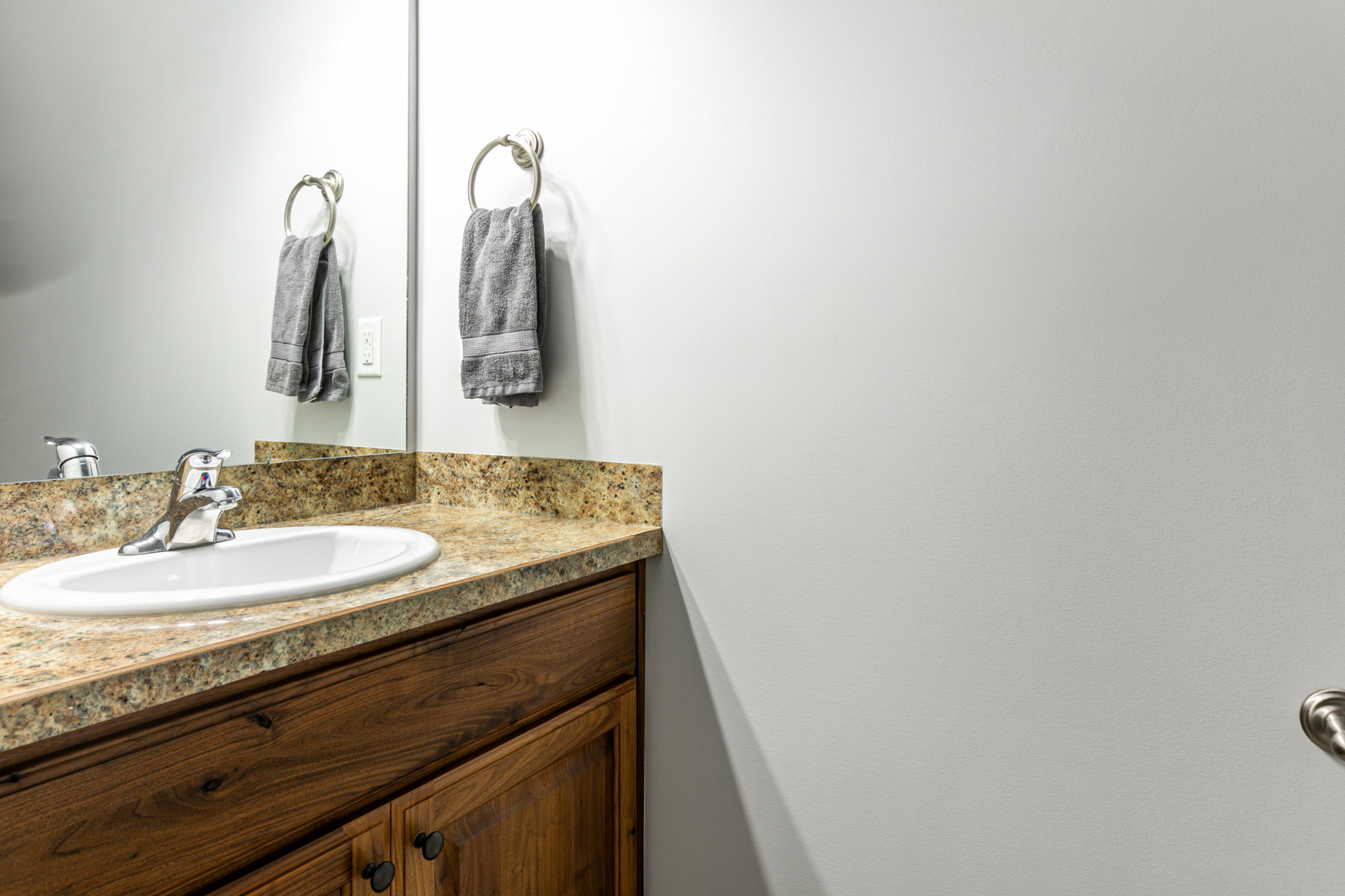 Bathroom vanity featuring a polished chrome faucet, an oval undermount sink, and a light-toned countertop