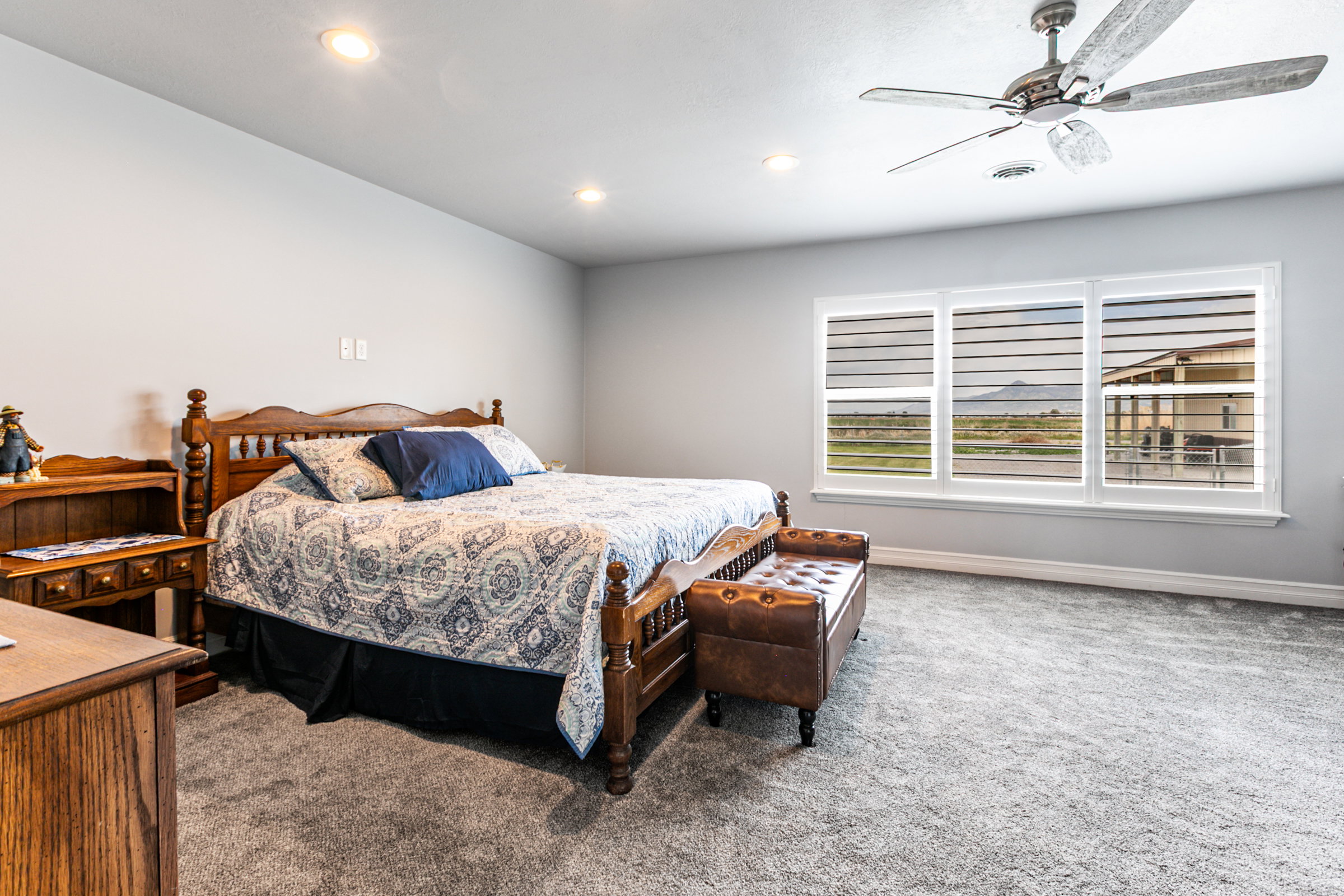 Carpeted room featuring recessed lighting, a ceiling fan, and multiple windows with plantation shutters
