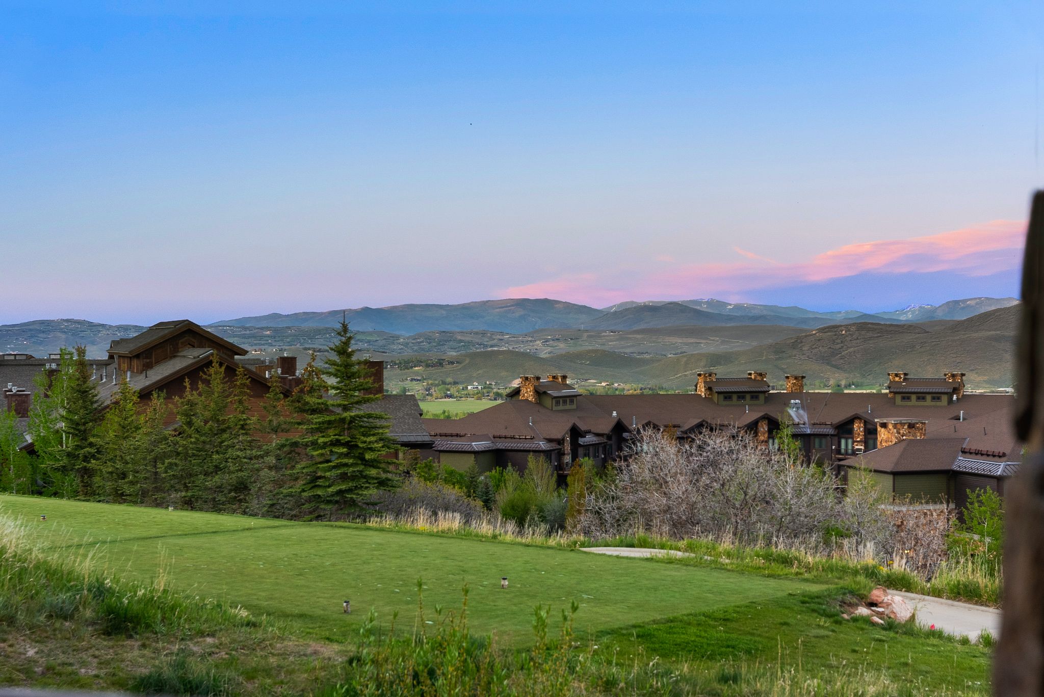 Manicured putting green with distant mountain ranges