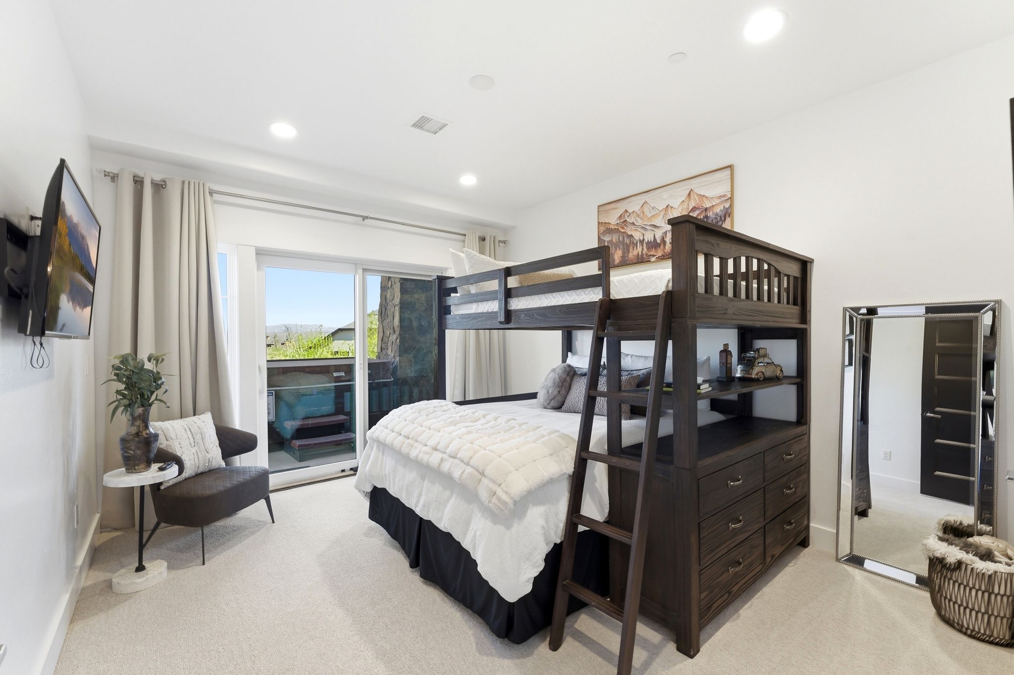 Carpeted room featuring a dark wood-finish bunk bed with built-in storage, a wall-mounted television, and recessed lighting