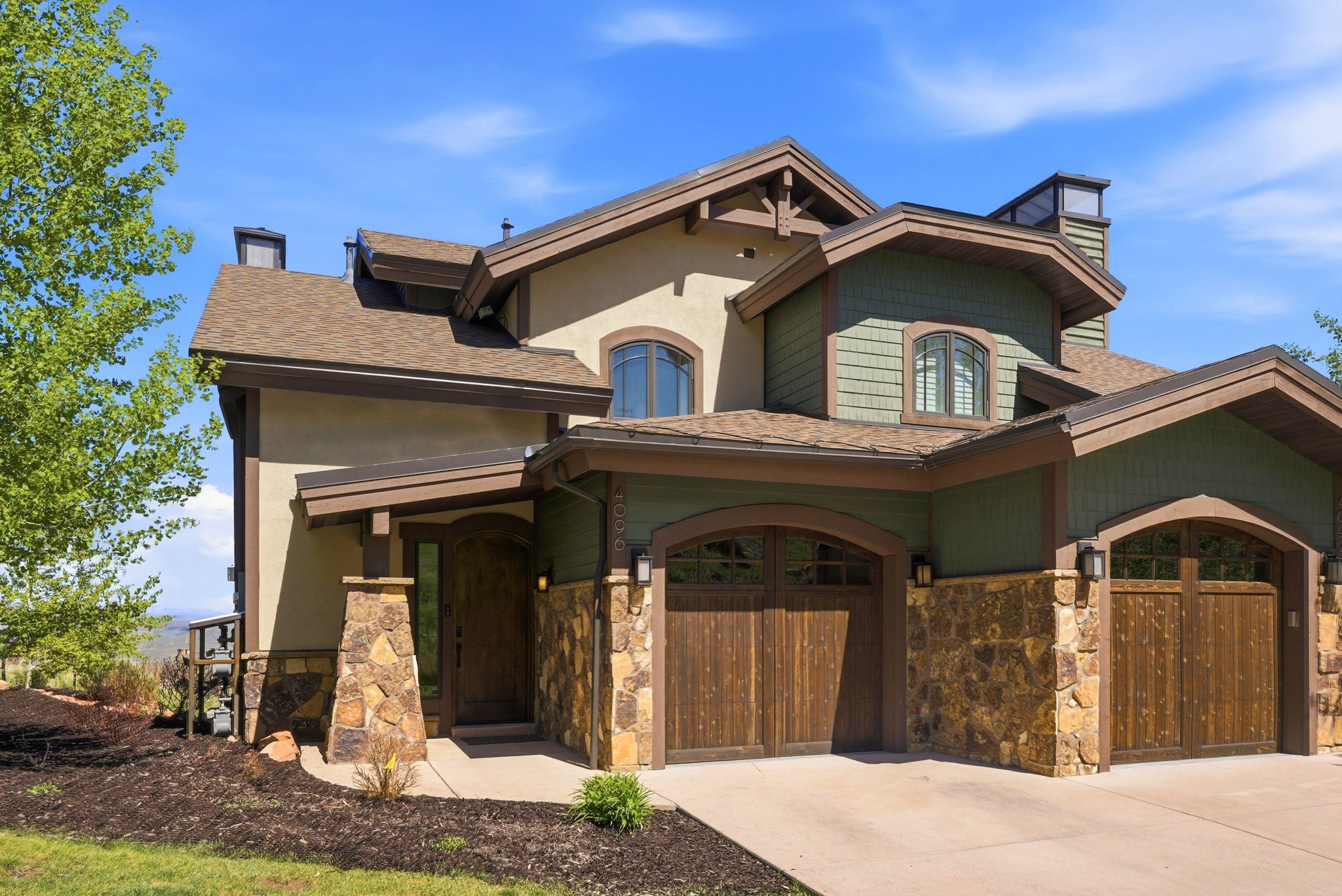 Contemporary multi-level residence featuring a stucco and stone exterior