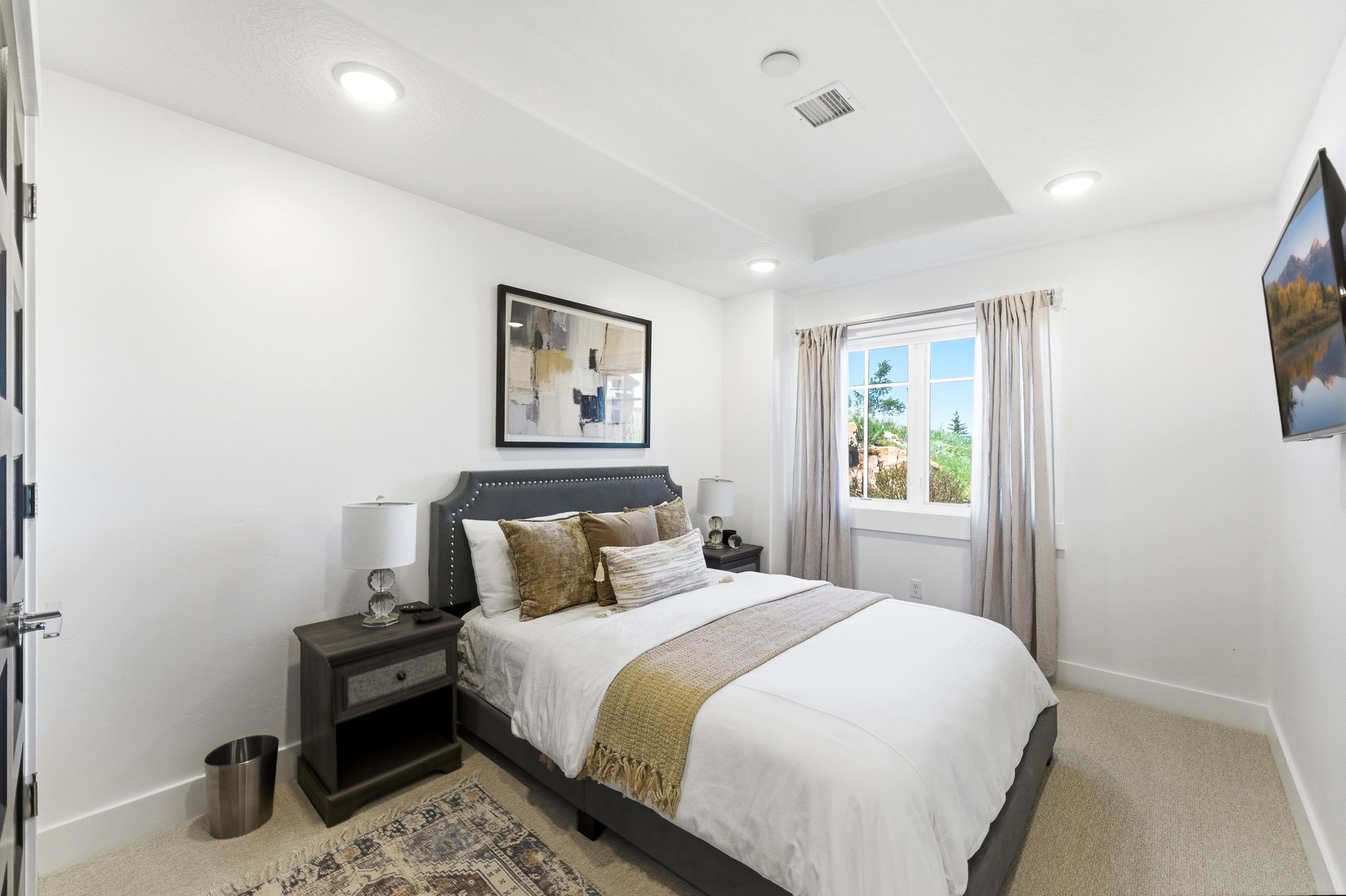 Bright room featuring a window with natural light, recessed lighting, and a tray ceiling