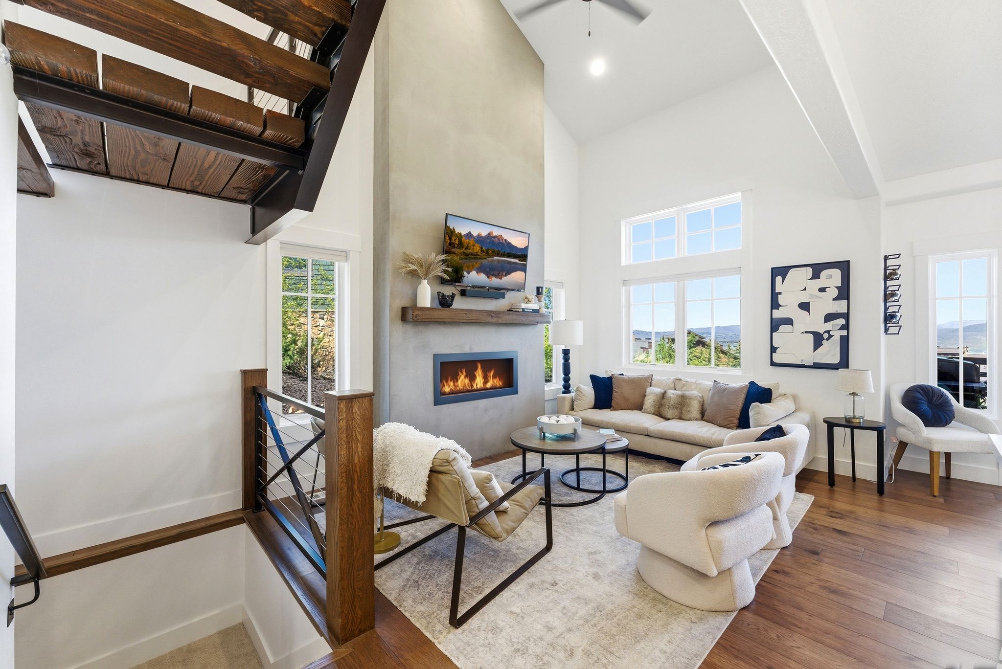 Spacious living area featuring a tall fireplace with a natural wood mantel
