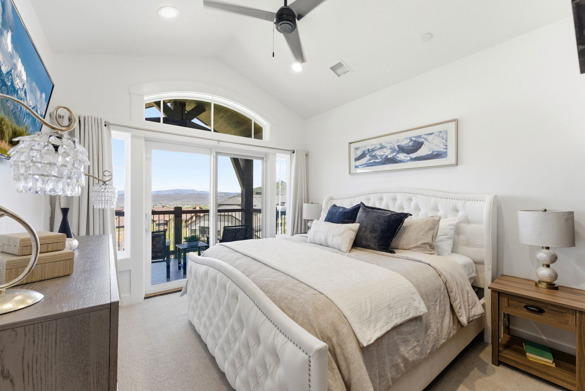 Spacious bedroom featuring vaulted ceilings, a ceiling fan, plush carpeting, and a private balcony with sliding glass doors