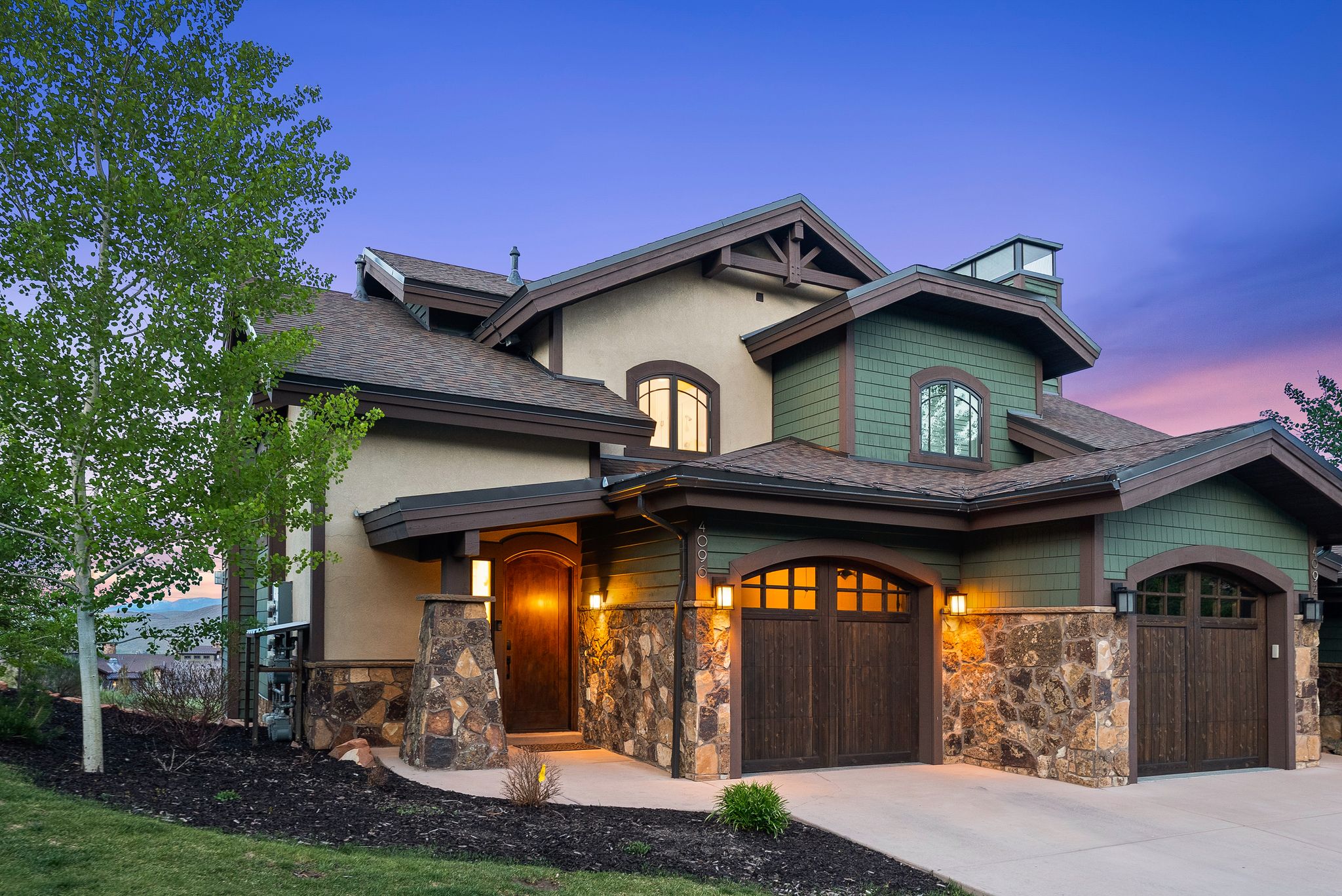 Front exterior featuring a multi-gabled roofline and a combination of stucco and shingle siding