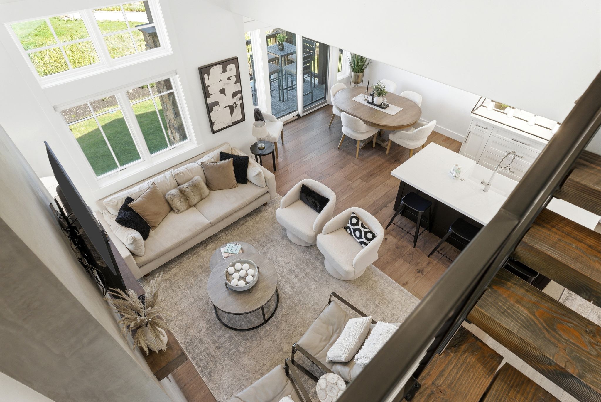 Open-concept living area with soaring ceilings and abundant natural light from large windows