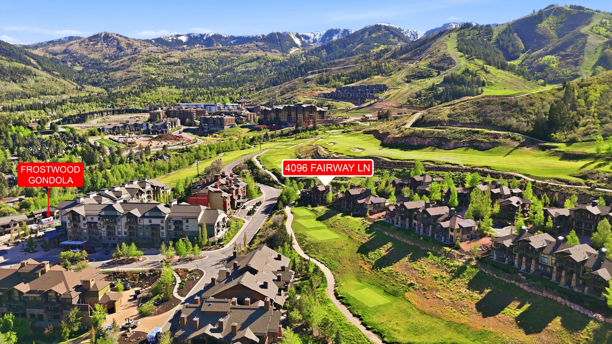 Aerial perspective featuring a residential community amidst lush green mountains
