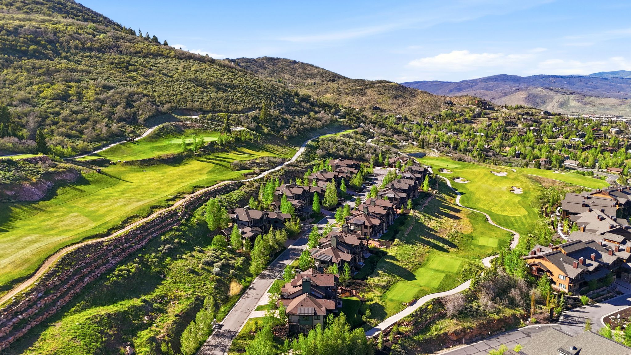 Residential community featuring golf course frontage, paved roadways, and mature tree landscaping