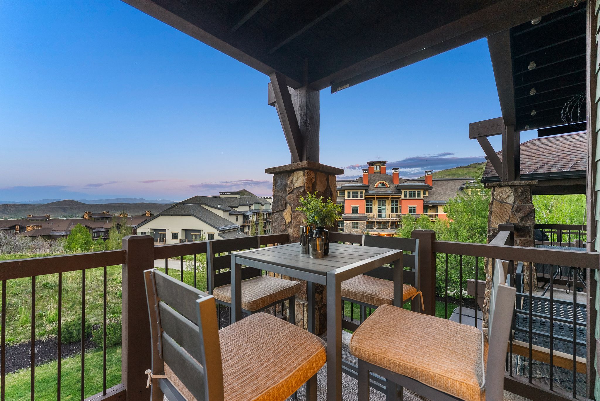 Covered balcony featuring stone-clad columns and dark wood beams