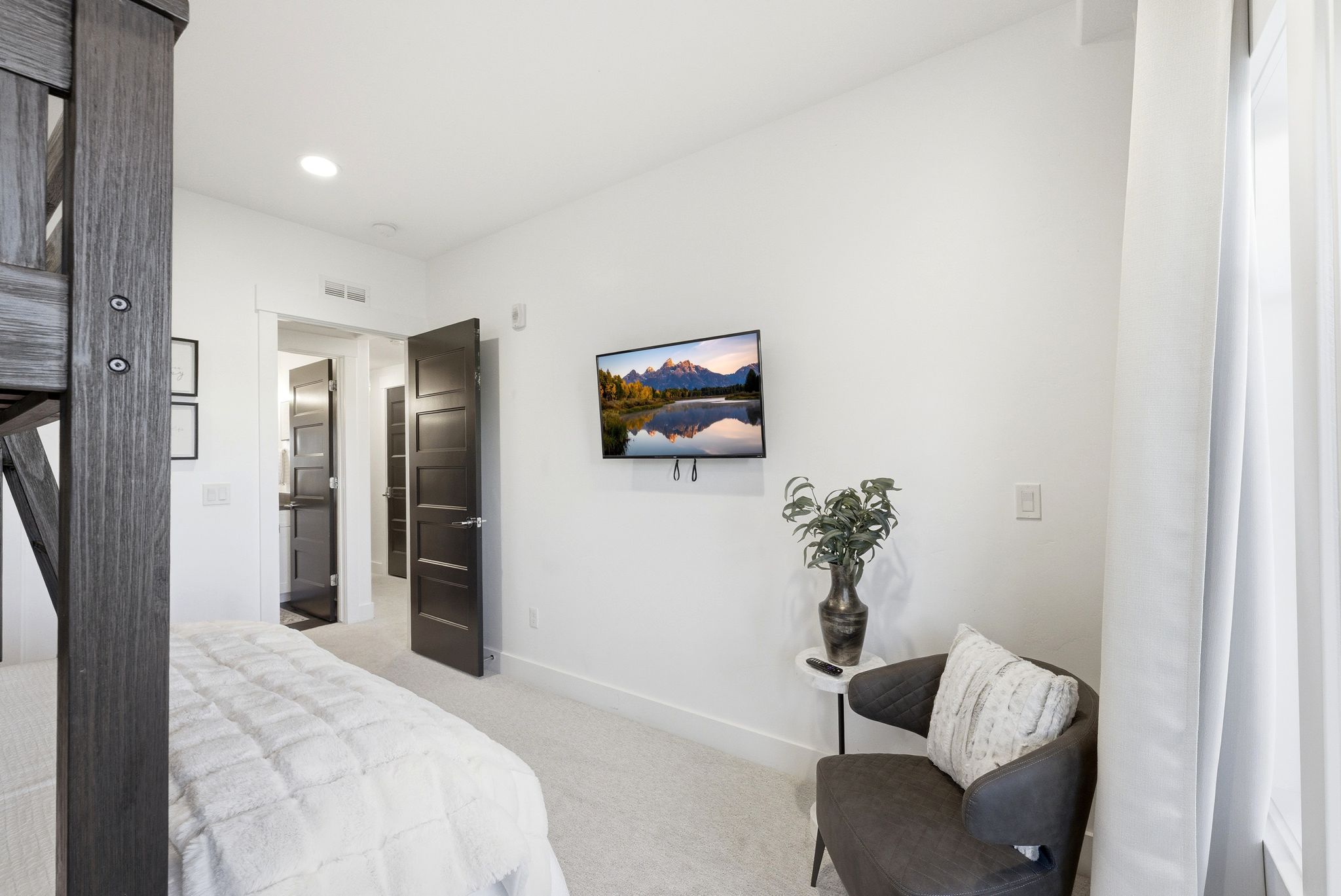 Bedroom featuring light gray carpeting, recessed lighting, and a wall-mounted television