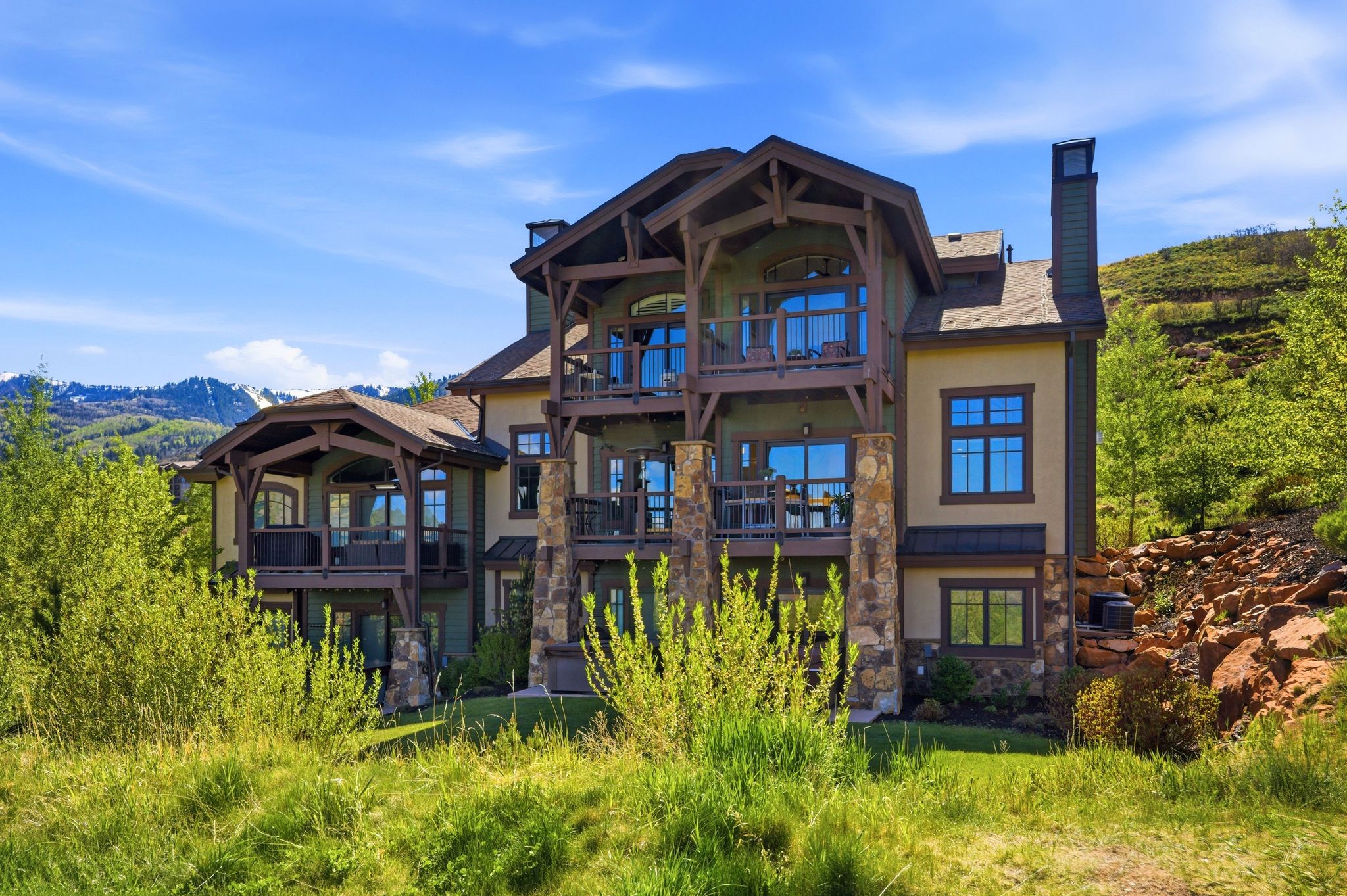 Multi-level residence featuring extensive balconies and stone column accents