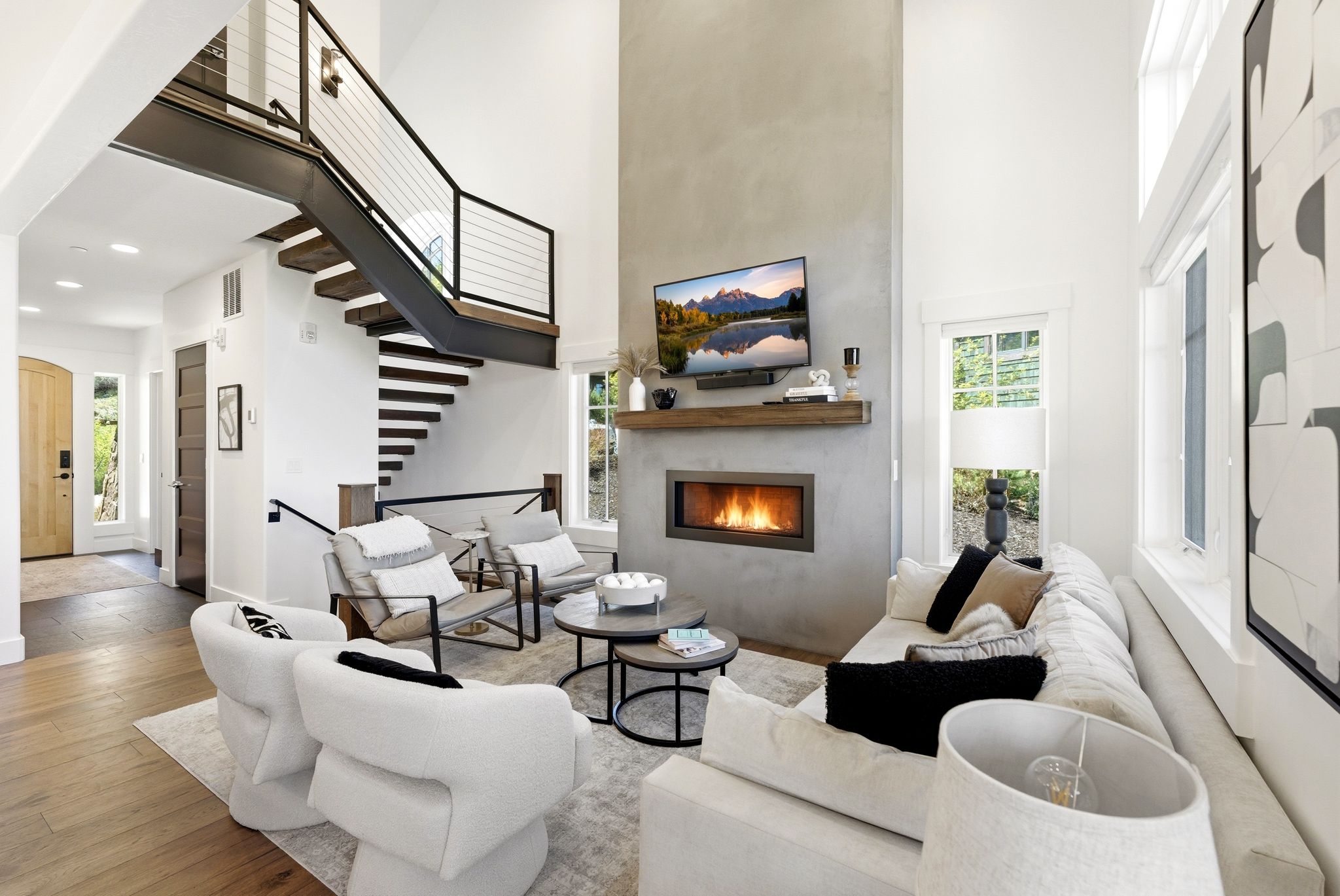 Double-height living area featuring a linear gas fireplace with a concrete surround and a wood-finish mantel
