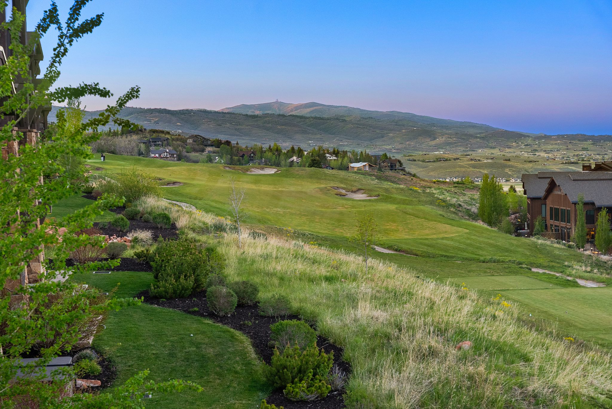 Expansive golf course setting featuring manicured greens and distant mountain ranges