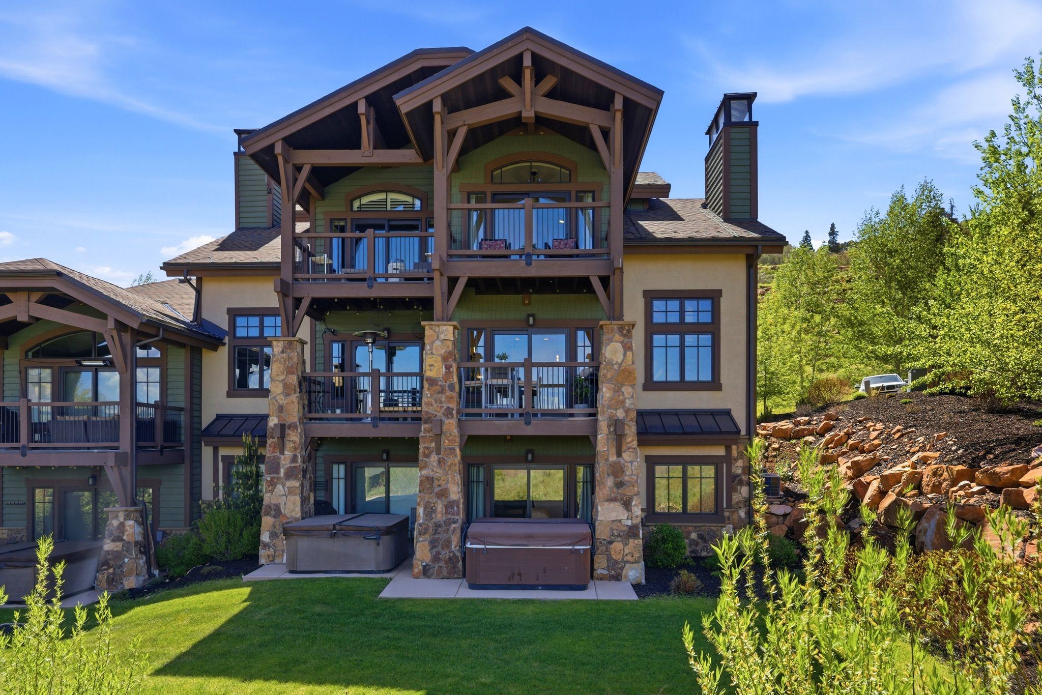 Multi-level structure featuring stacked balconies, stone columns, and wood-beam accents