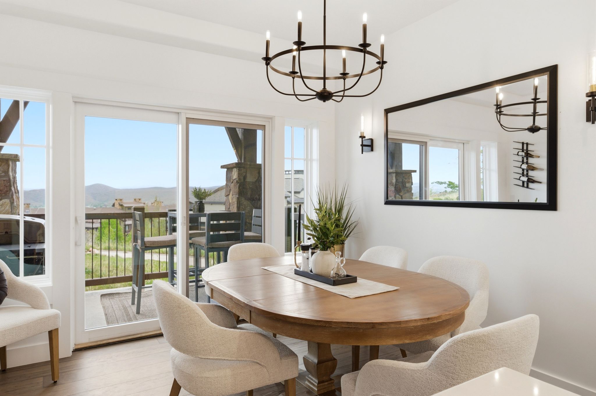 Dining area featuring a wood-finish floor, a black chandelier, and two wall sconces