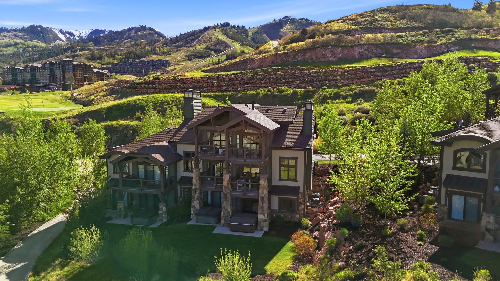 Multi-story residence featuring extensive balconies and stone accents