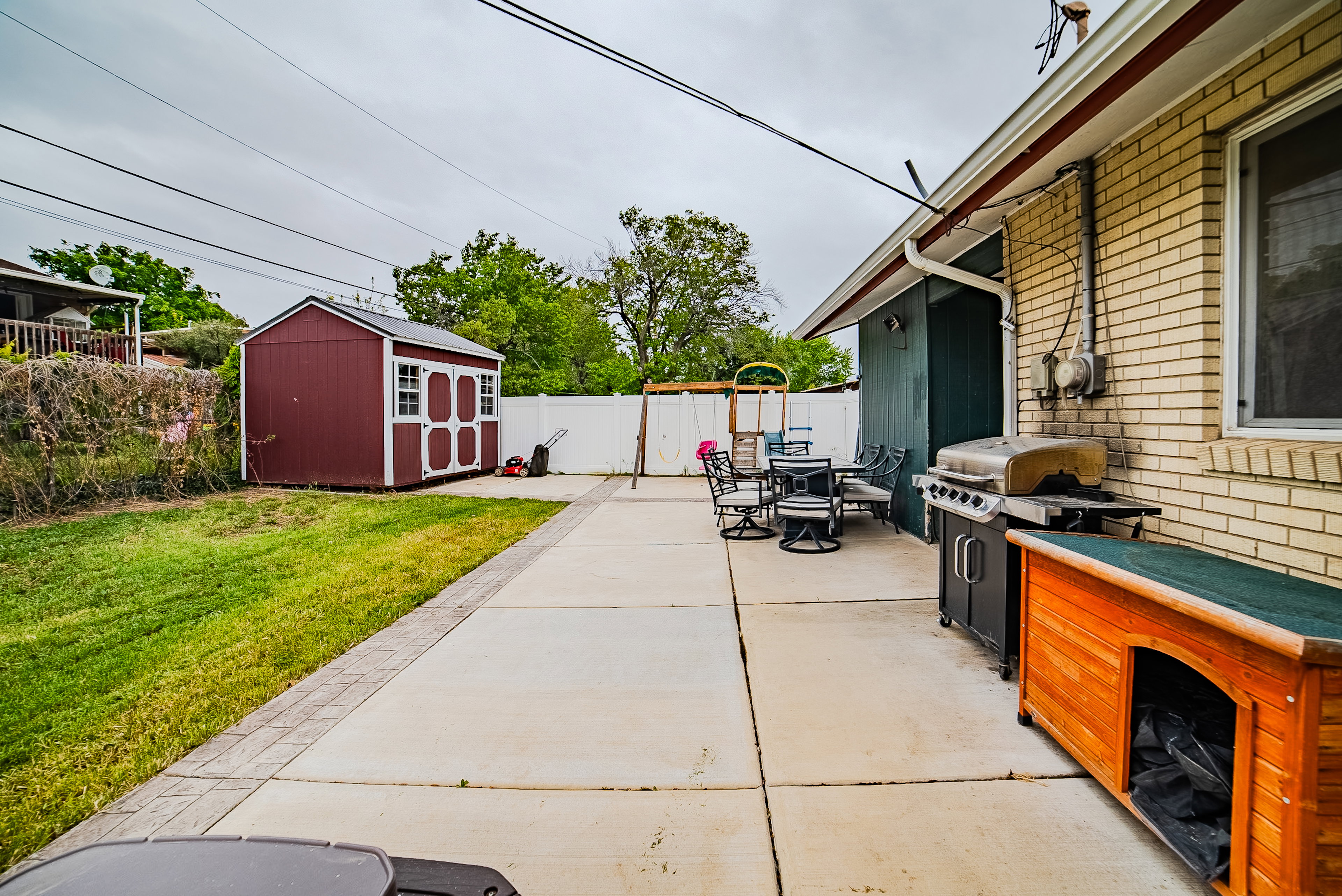 Expansive concrete patio area with brick exterior and white gutter system