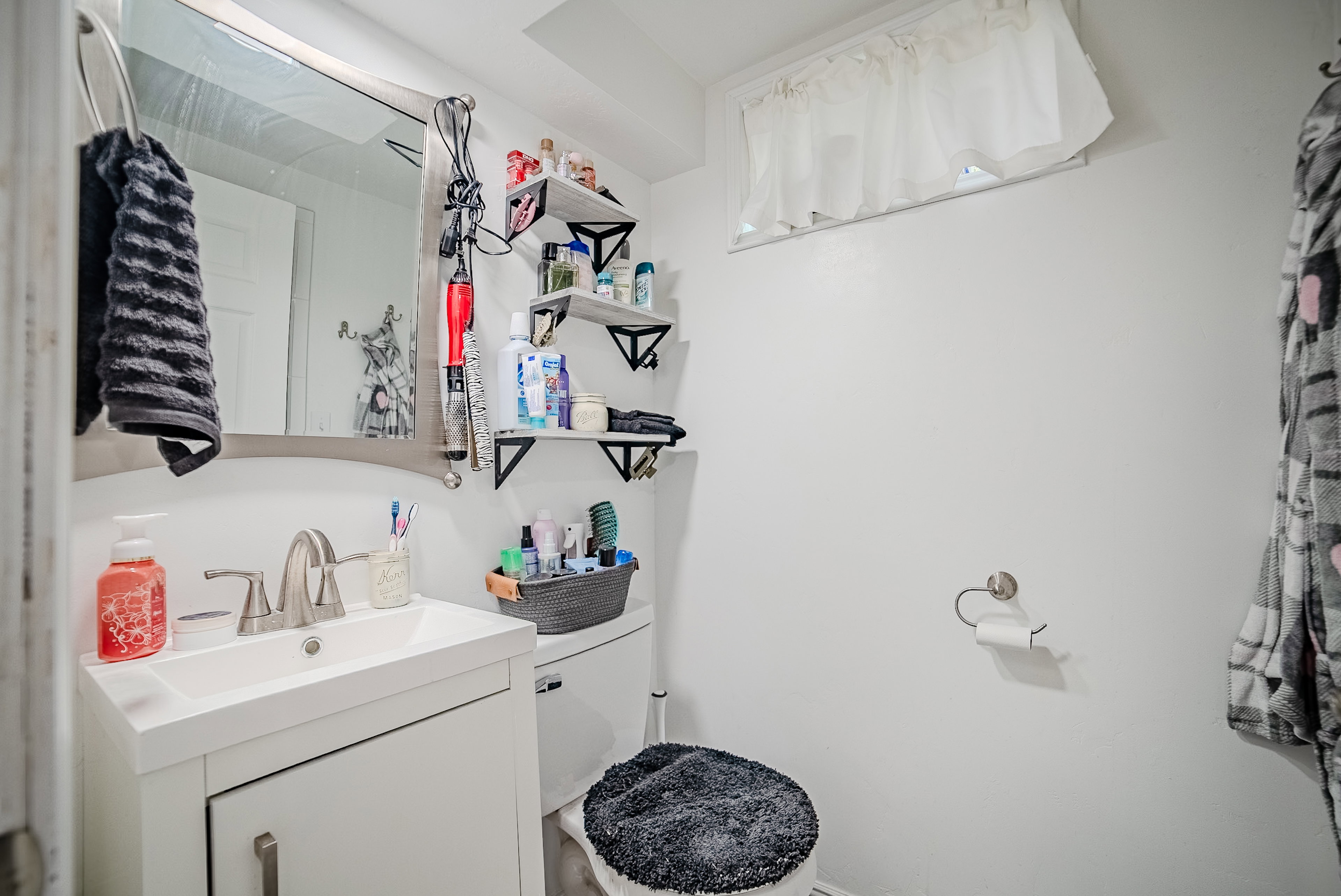 Bathroom vanity with a white rectangular sink and brushed nickel faucet