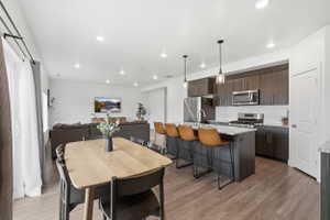 Open-concept living area with a kitchen island featuring a light-toned countertop and pendant lighting
