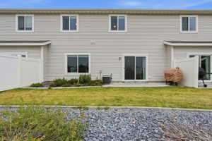 Rear exterior featuring neutral siding and a private patio with sliding glass door access