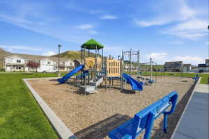Community playground featuring multiple slides, climbing structures, swings, and ground-level seating