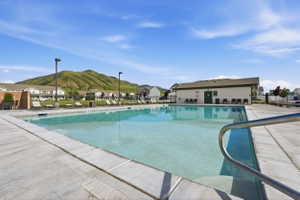Expansive outdoor swimming pool featuring a perimeter of concrete decking and a stainless steel entry railing