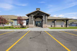 Contemporary building with a stone and wood-accented entrance, a paved parking area, and manicured landscaping
