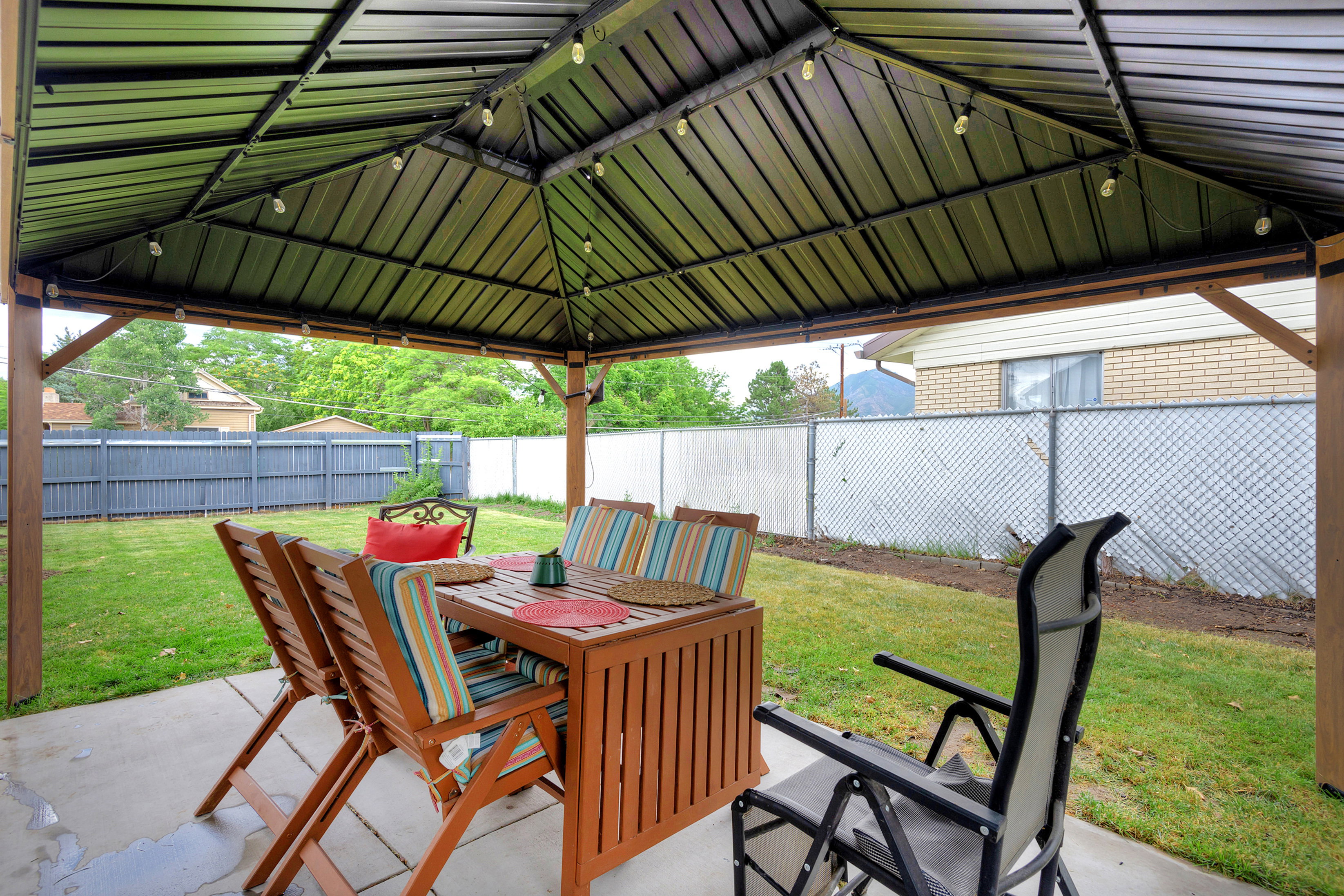Covered patio featuring a metal roof structure with integrated string lighting