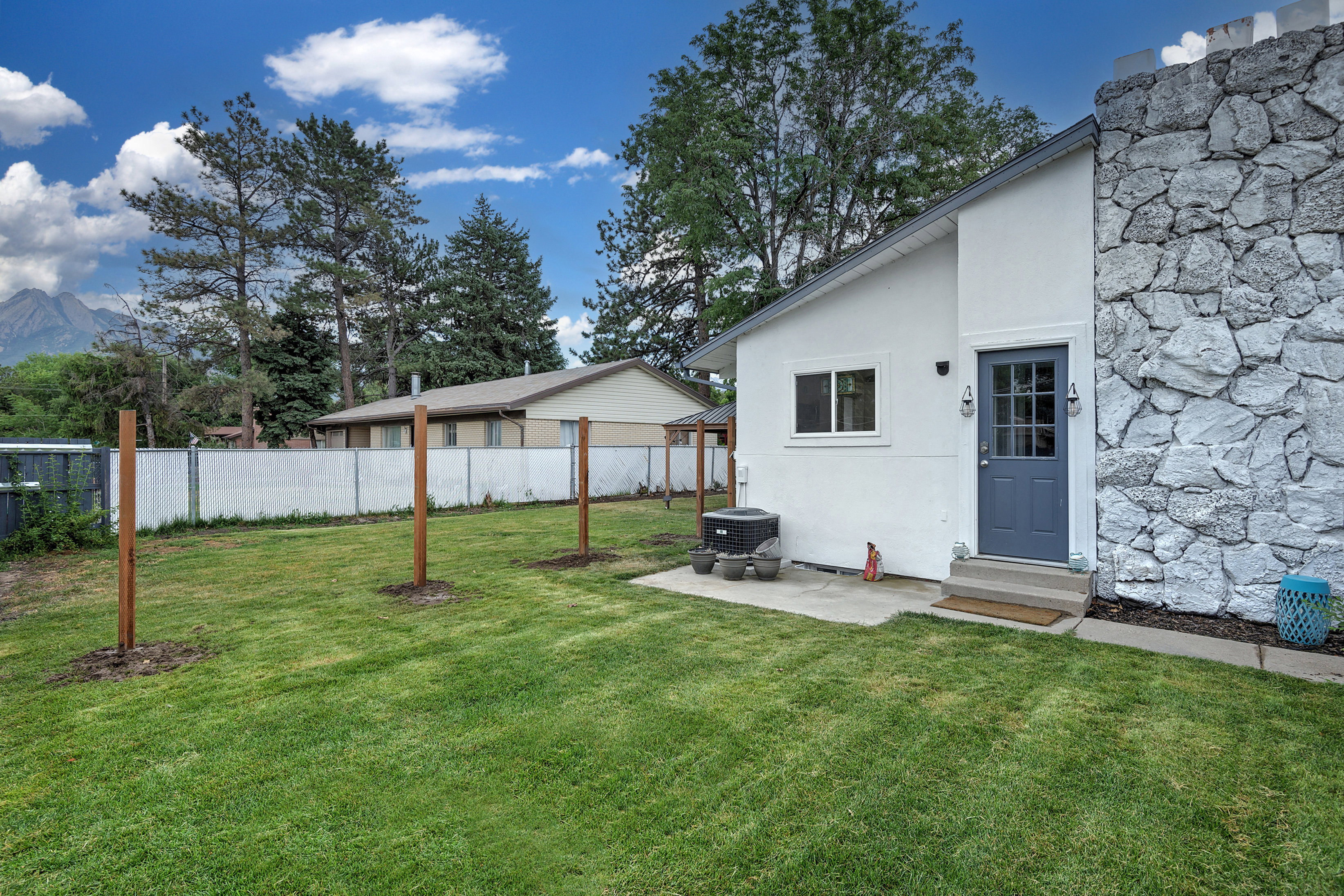 Expansive backyard featuring a manicured lawn, a concrete patio, and a privacy fence
