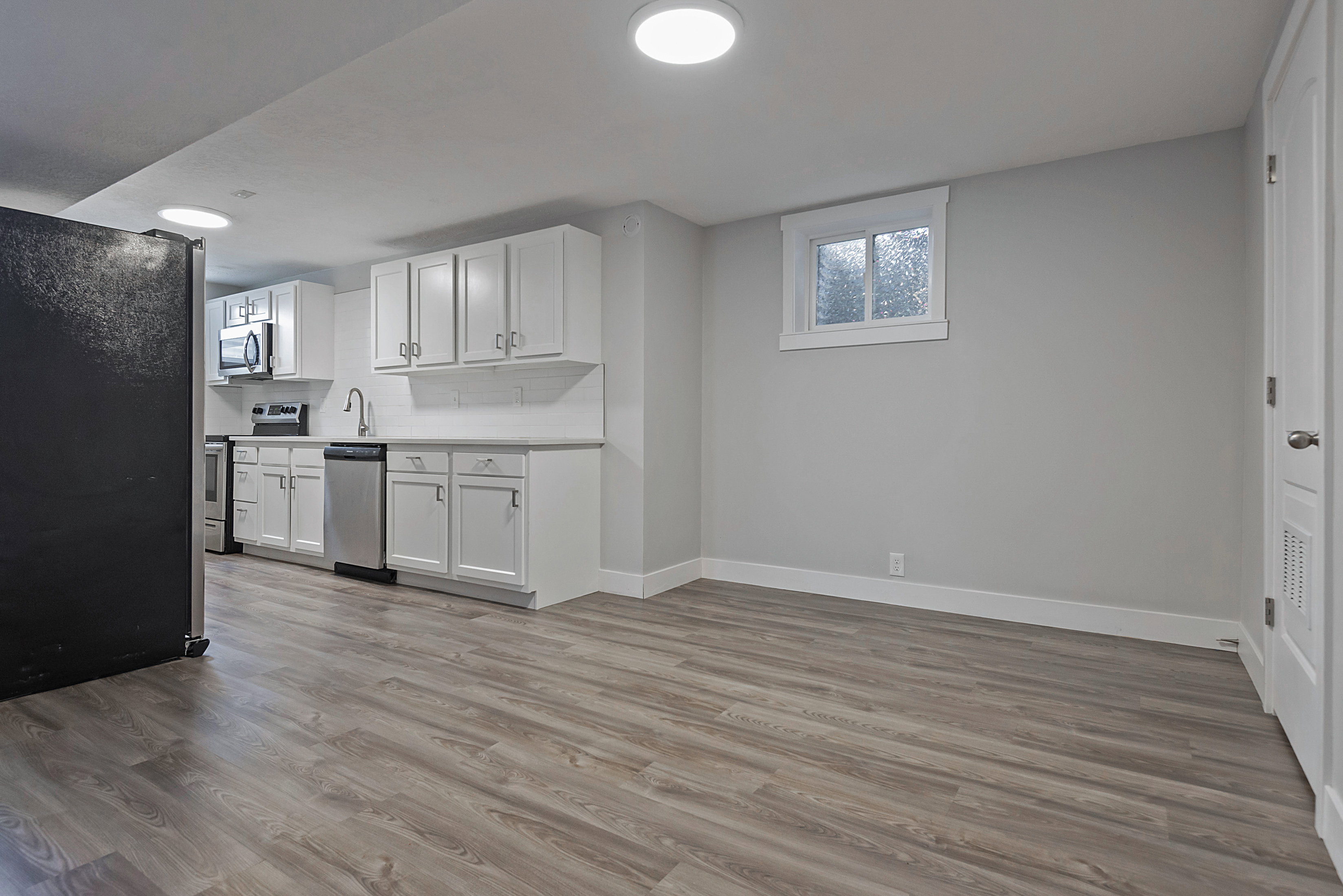 Lower-level living space featuring wood-finish flooring and recessed lighting