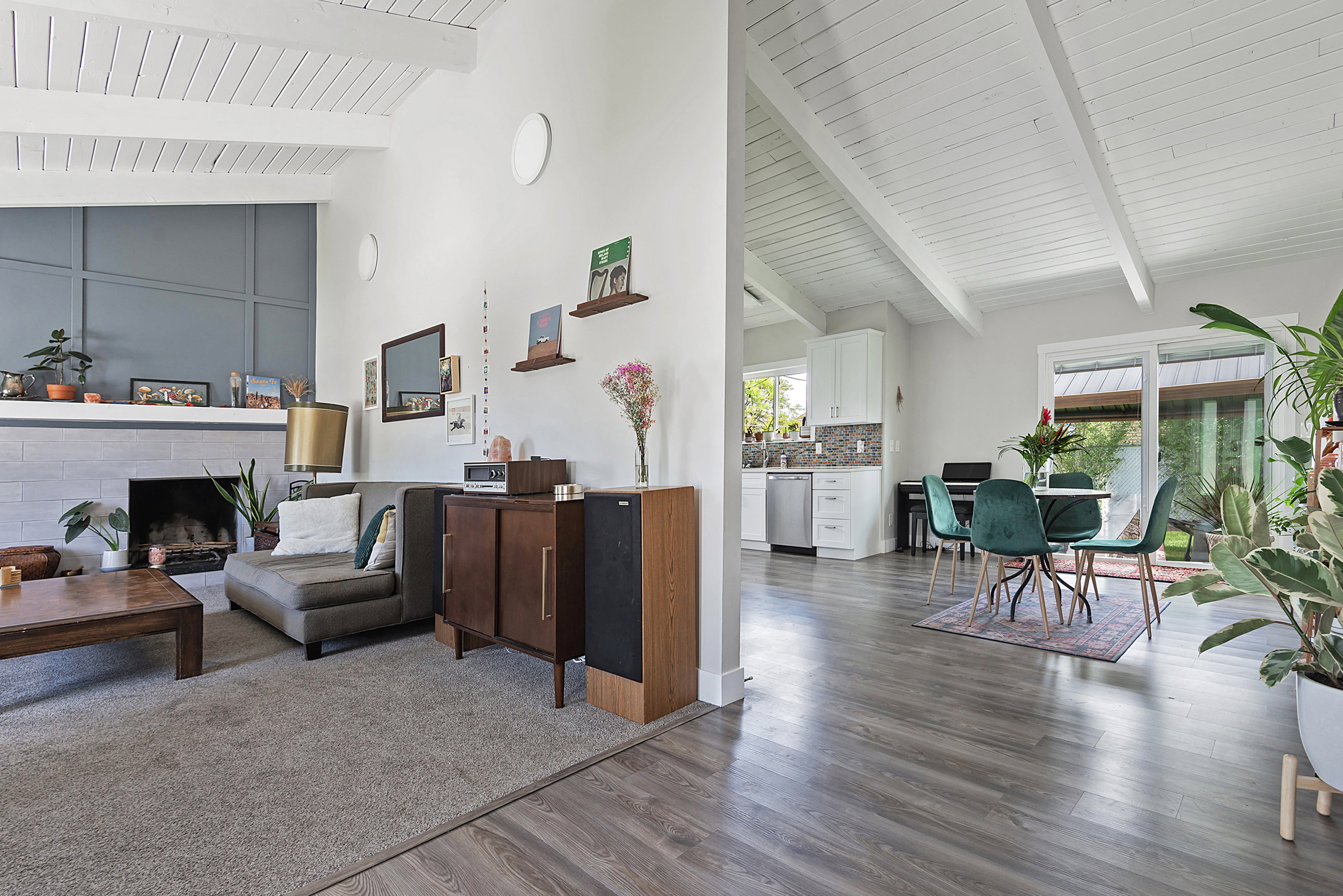Vaulted ceilings with exposed beams complement the open-concept design featuring wood-finish flooring