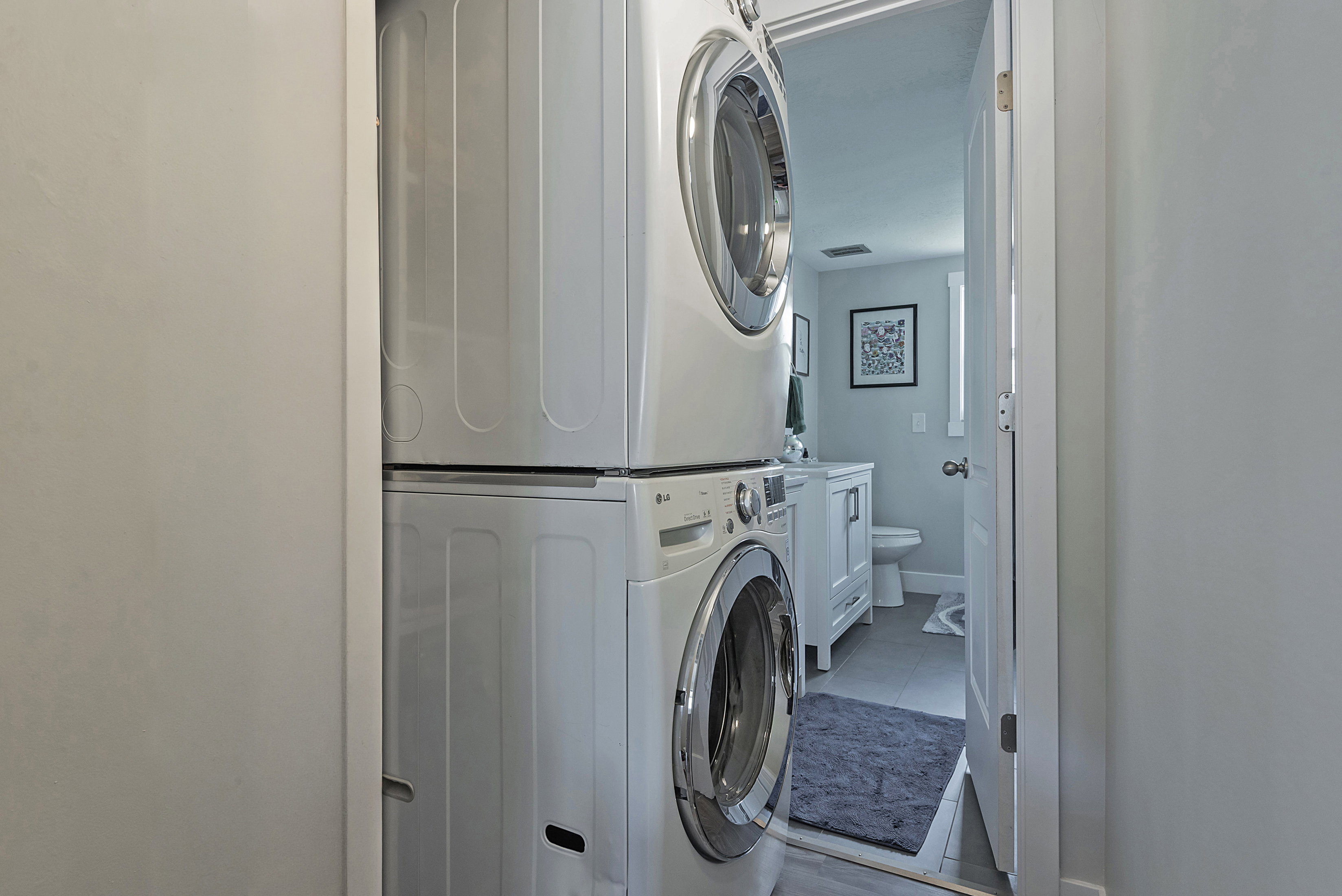 Dedicated laundry area featuring a stacked washer and dryer unit