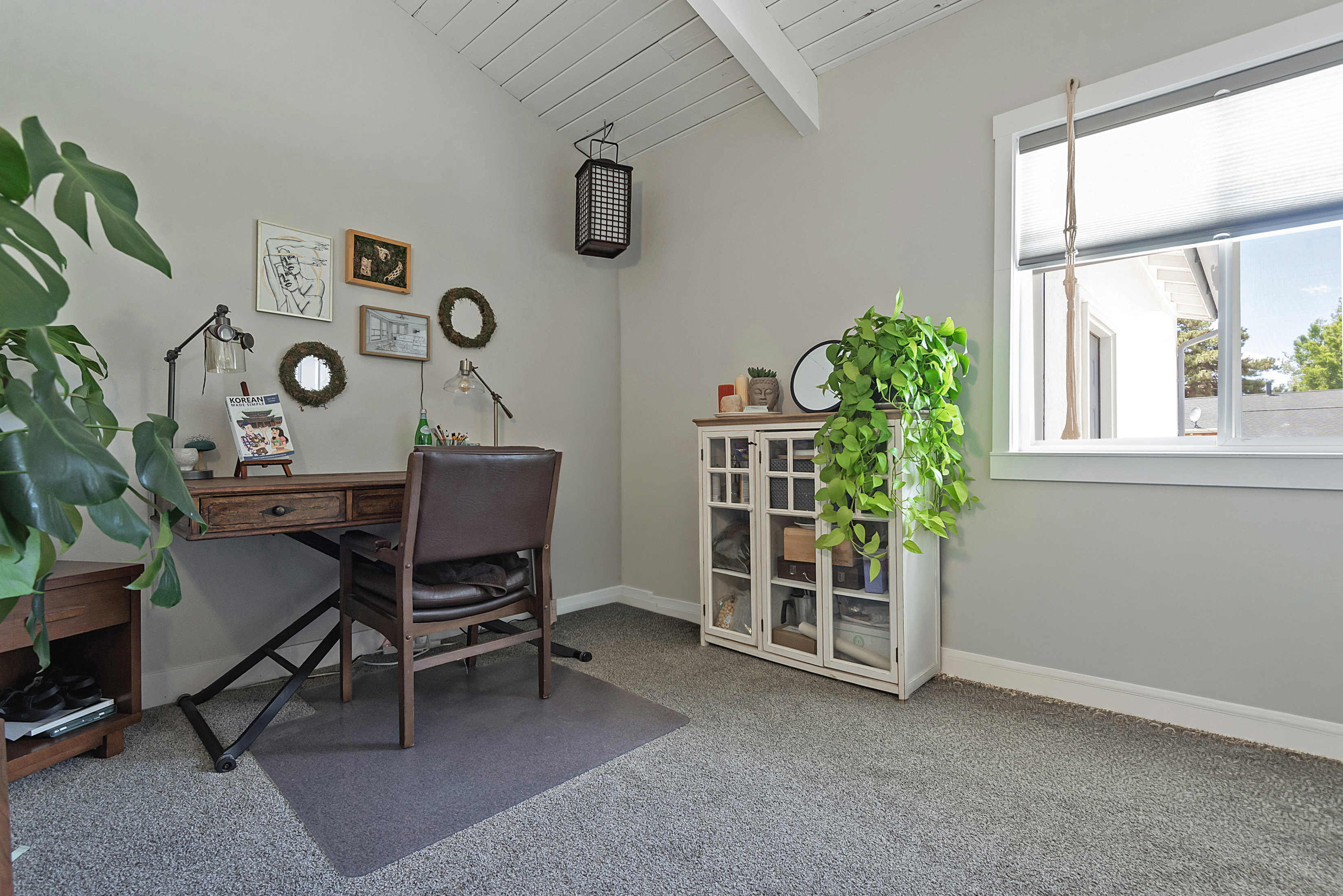 Vaulted tongue-and-groove ceiling, light gray wall finishes, and a window with white trim
