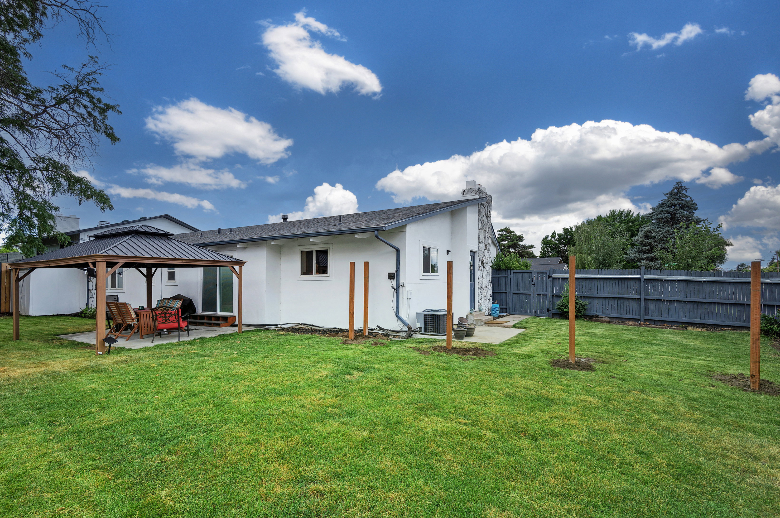Expansive green lawn with a patio featuring a pergola