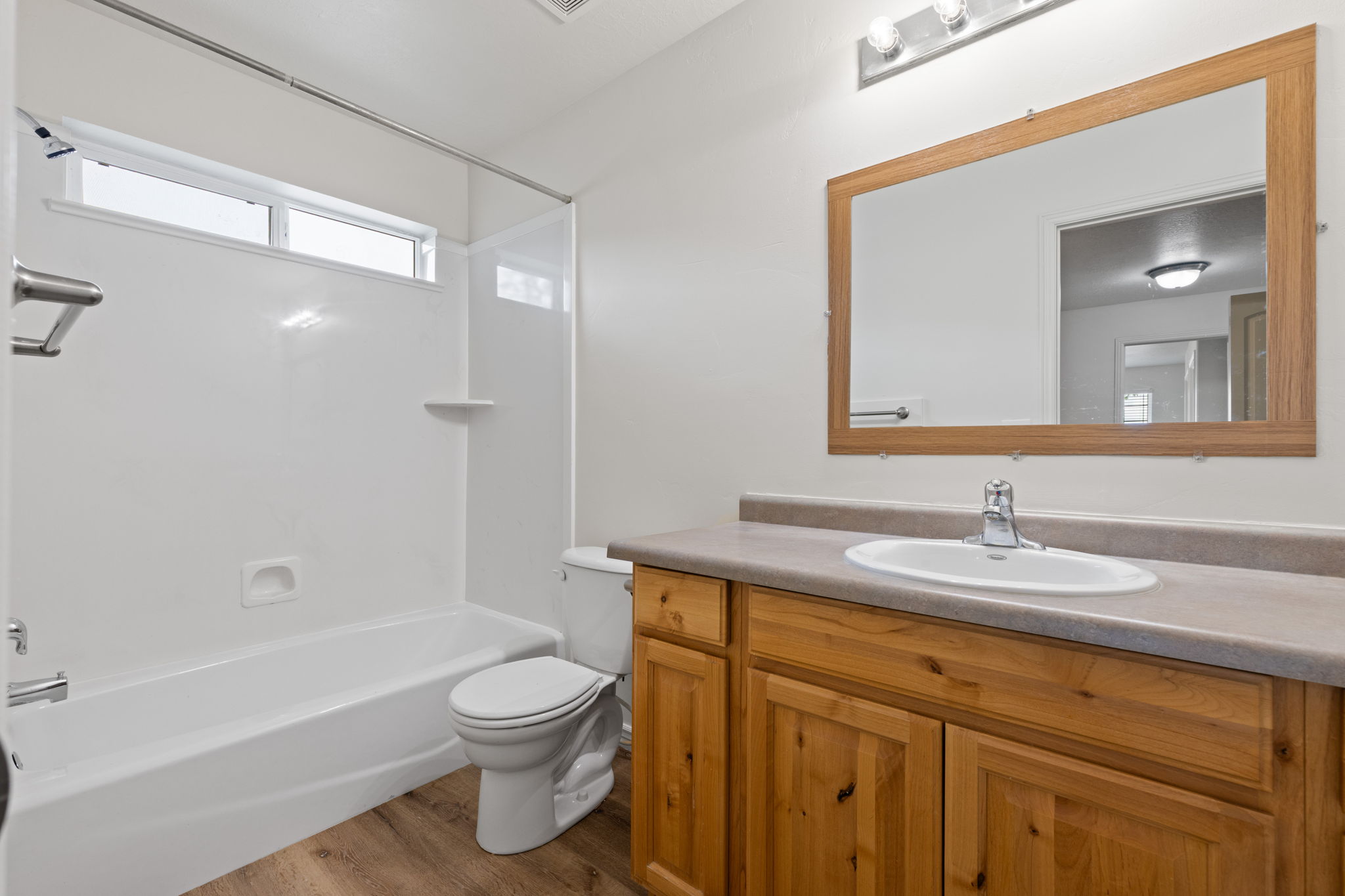 Second floor spare bathroom featuring spacious vanity, decorative mirror, and tub/shower combination