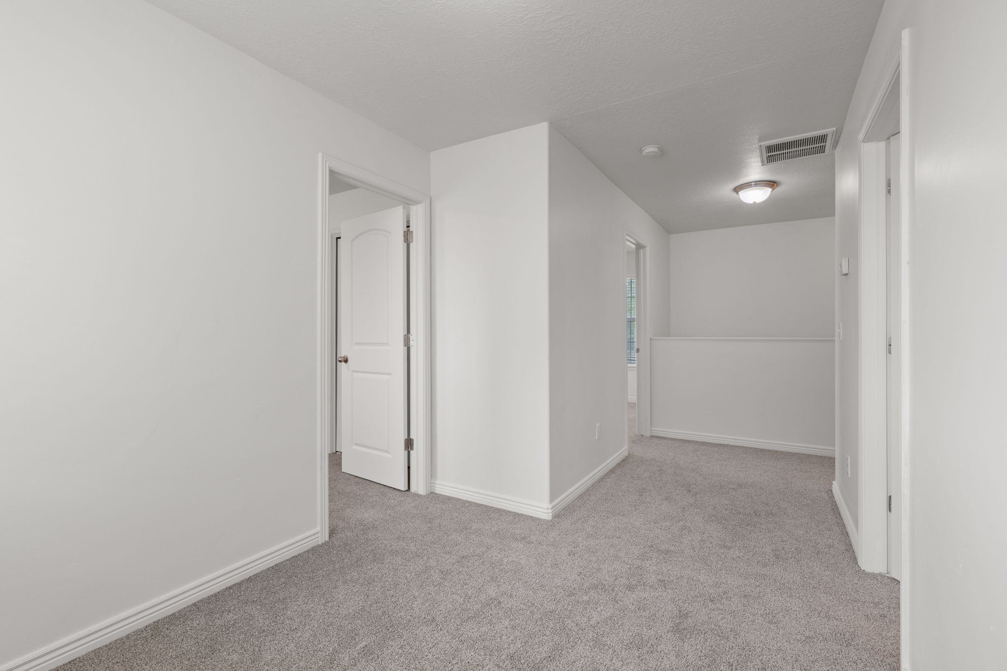 Hallway area featuring new carpet and light paint