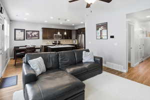 Open-concept living area with wood-finish flooring, recessed lighting, and a ceiling fan