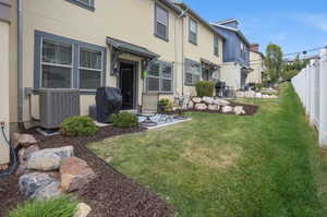 Expansive backyard featuring a concrete patio, a privacy fence, and rock landscaping