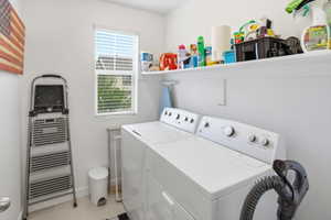Dedicated laundry area featuring a window with blinds, a built-in white shelf, and light-toned flooring