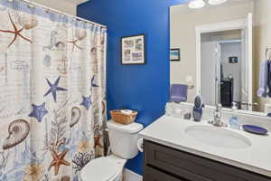 Bathroom featuring a white oval undermount sink, a chrome faucet, and a stone-finish countertop