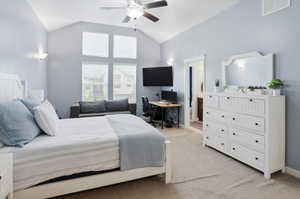 Vaulted ceiling bedroom featuring ample natural light from multiple windows, a ceiling fan fixture, and wall-mounted lighting