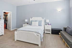 Spacious bedroom with light blue walls and neutral carpet