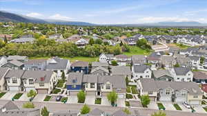Expansive suburban neighborhood featuring a variety of architectural styles, individual garages, and mountain backdrops