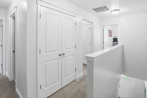Upper level hallway featuring plush carpet flooring, white paneled doors, contemporary trim work, and a semi-flush mount ceiling light