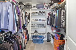 Walk-in closet featuring carpet flooring, built-in shelving, and multiple hanging rods for organization